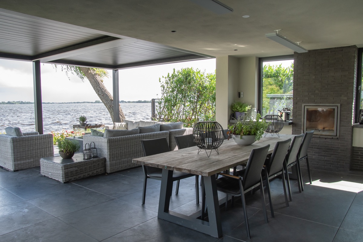Overdekt terras met eettafel en uitzicht over het water